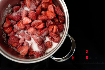 Making sweet strawberry jam in kitchen. Summer food concept. Top view