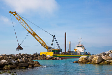 Ship for construction of a sea barrier with stone boulders to li