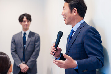 マイクを使って演説をする中年の男性