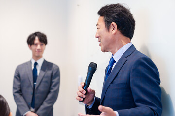 マイクを使って演説をする中年の男性