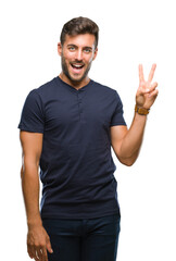 Young handsome man over isolated background smiling with happy face winking at the camera doing victory sign. Number two.