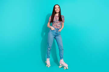 Full length photo of adorable cheerful girl wear striped t-shirt riding rollers empty space isolated teal color background