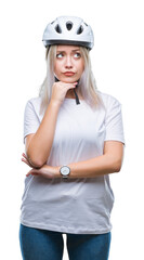 Young blonde woman wearing cyclist security helmet over isolated background with hand on chin thinking about question, pensive expression. Smiling with thoughtful face. Doubt concept.