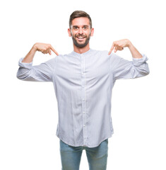 Young handsome man over isolated background looking confident with smile on face, pointing oneself with fingers proud and happy.