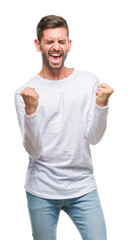 Young handsome man over isolated background very happy and excited doing winner gesture with arms raised, smiling and screaming for success. Celebration concept.