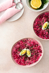 Summer cold beetroot soup made from beets, radishes, cucumbers, potatoes and herbs, garnished with egg, a refreshing summer lunch