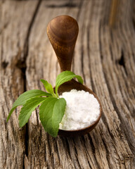 Stevia rebaudiana, sweet leaf sugar substitute isolated in wooden spoon on wooden background