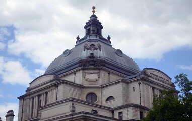 Fototapeta premium Methodist Central Hall's dome against a cloudy sky with architectural details visible.