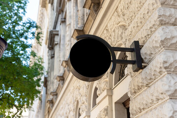 Modern round company sign on an city facade in black. Combines contemporary design with city charm...
