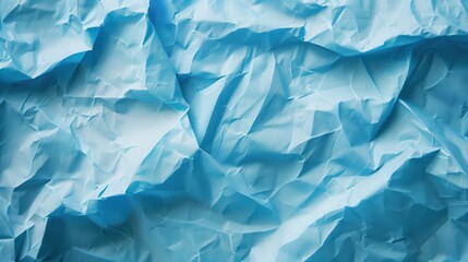 Fototapeta premium Close-up of wrinkled blue paper texture, ideal for scrapbooking and crafting. Top view