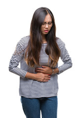 Young asian woman wearing glasses over isolated background with hand on stomach because indigestion, painful illness feeling unwell. Ache concept.