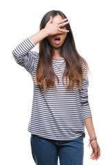 Fototapeta premium Young asian woman wearing glasses over isolated background peeking in shock covering face and eyes with hand, looking through fingers with embarrassed expression.