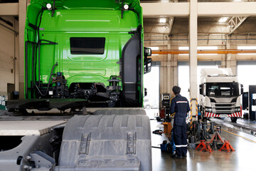 automobile mechanic checking truck in the garage. truck maintenance in a garage with mechanics....
