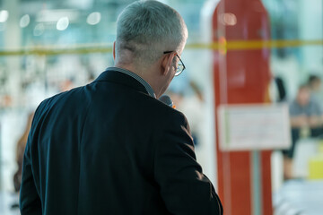 Business professional giving a speech at a conference event. The image captures a back view of the speaker holding a microphone.
