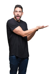 Young handsome man over isolated background Pointing to the side with hand and open palm, presenting ad smiling happy and confident