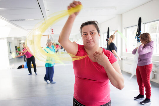 Portrait of woman with disability exercising with friends in fitness studio
