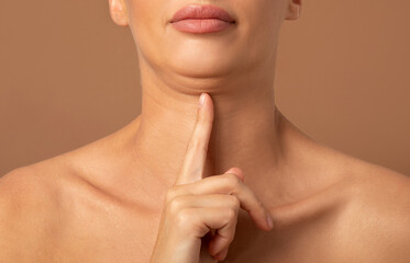 Closeup of woman showing second chin, problems with excess weight, demonstrating her cosmetic...