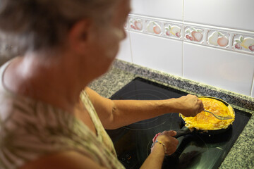 Senior Woman Flipping Spanish Tortilla