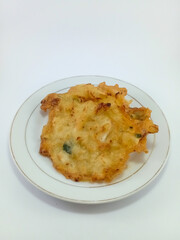 Bakwan: Traditional Indonesian Vegetable Fritter, a Popular Gorengan Delight, Artfully Plated on a White Dish Against a Clean White Background, Perfect for Authentic Culinary Exploration and Enjoyment