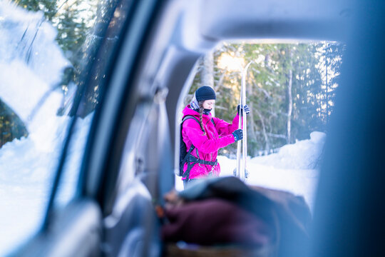 Mid adult woman holding ski bindings in winter