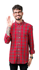 Young handsome man wearing glasses over isolated background Waiving saying hello happy and smiling, friendly welcome gesture