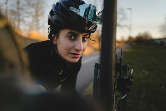 Portrait of mid adult woman repairing bicycle at back yard