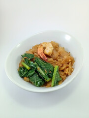 Kwe Tiau with Assorted Toppings: Stir-Fried Rice Noodles Loaded with Fresh Veggies, Eggs, and Succulent Shrimps, Expertly Presented on a Clean White Background, Perfect for Exploring Southeast Asia