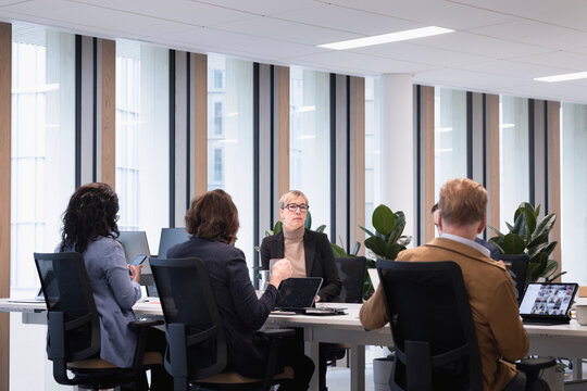 Corporate coworkers discussing over conference table in office