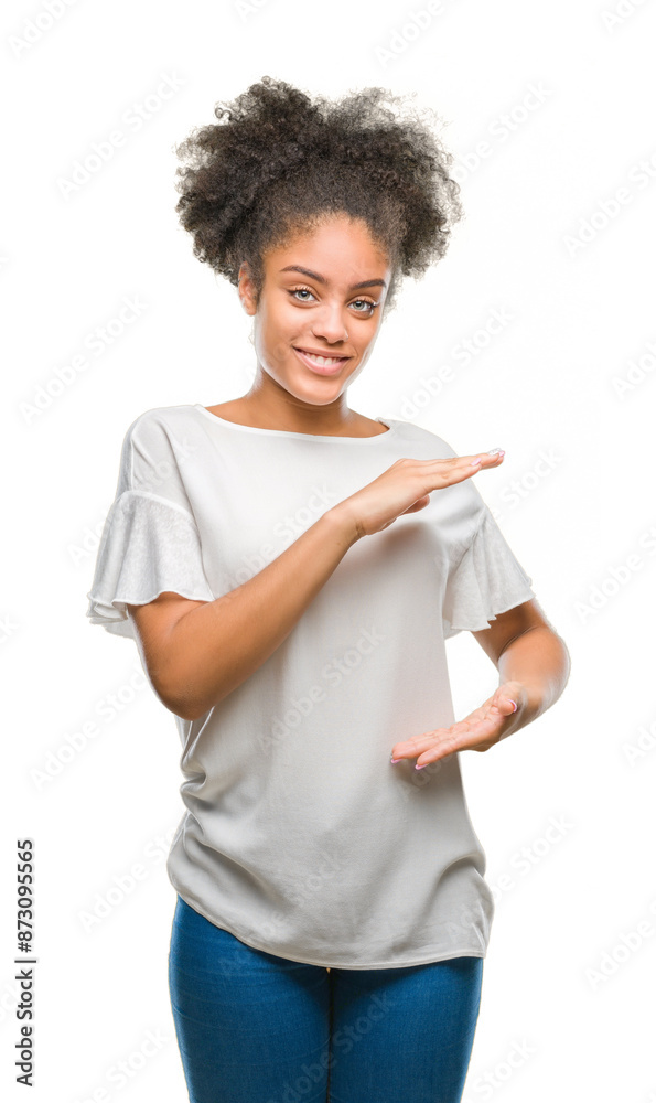 Sticker Young afro american woman over isolated background gesturing with hands showing big and large size sign, measure symbol. Smiling looking at the camera. Measuring concept.