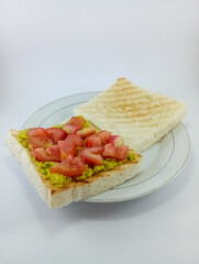 Mashed Avocado and Diced Tomato on Toast: A delicious and nutritious breakfast choice featuring creamy mashed avocado and juicy diced tomato atop crispy toast on White Background