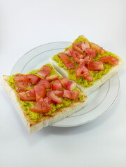 Mashed Avocado and Diced Tomato on Toast: A delicious and nutritious breakfast choice featuring creamy mashed avocado and juicy diced tomato atop crispy toast on White Background