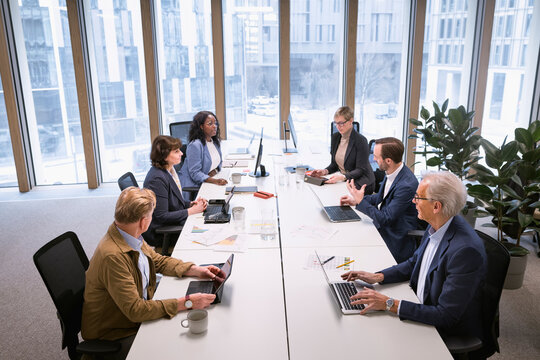 High angle view of business colleagues discussing over conference table in office