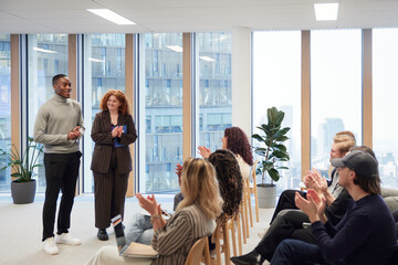 Multiracial business people applauding for achievements during meeting in office