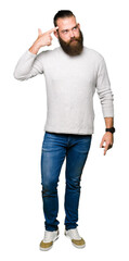 Young blond man wearing casual sweater Shooting and killing oneself pointing hand and fingers to head, suicide gesture.