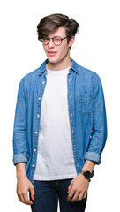 Young handsome man wearing glasses over isolated background winking looking at the camera with sexy...