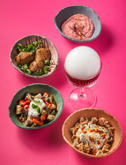 Set of vegetarian bowls on a vibrant pink/orange background with an explosion drink. Modern concept.