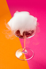 Drink with smoke on a vibrant pink/orange background. Explosion drink. Exotic drink.