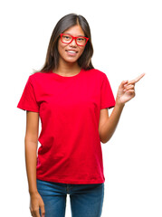 Young asian woman wearing glasses over isolated background with a big smile on face, pointing with hand and finger to the side looking at the camera.