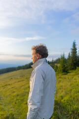 man on a hill overlooking a mountain range, against the background of mountains, tourism, hiking, time together, family, relationships, nature of the Carpathian, vacation, outdoor activities, meditati