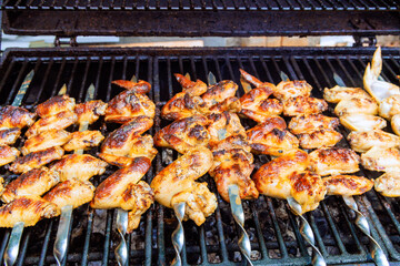 American cuisine with chicken wings being grilled on charcoal BBQ