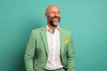 Portrait of a cheerful man in his 40s wearing a professional suit jacket isolated in pastel green background