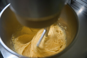 Close-up view into the mixer bowl kneading dough