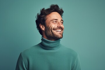 Obraz premium Portrait of a jovial man in his 30s wearing a classic turtleneck sweater on pastel teal background