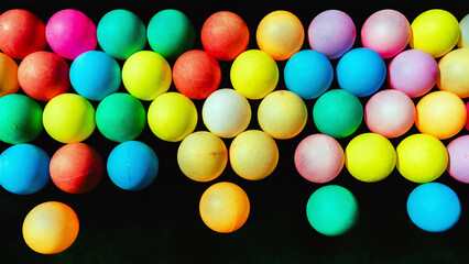 Top view of many colorful plastic balls on water. View of colored sponge balls. Many colorful balls as background. Lots of colorful balls for children to play in the water park. Toy pool for kids.