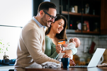 Portrait of business man using laptop working while family in background at home.