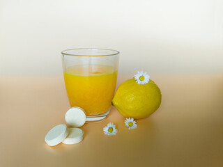 Vitamin effervescent tablets and lemons on beige grunge table