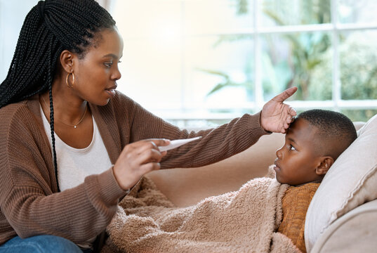 Forehead, sick and mom with child in bed with allergy, cold and flu in home with worried single parent. Illness, African mother or hand on son for temperature check for fever with thermometer or care