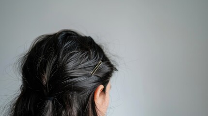 Fototapeta premium Black hair clip held against white backdrop