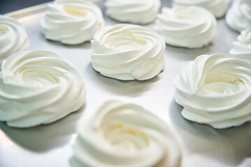 Fluffy and sticky milk white zefir cooling down on iron tray