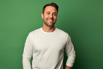 Fototapeta premium Portrait of a happy man in his 30s sporting a long-sleeved thermal undershirt in front of soft green background